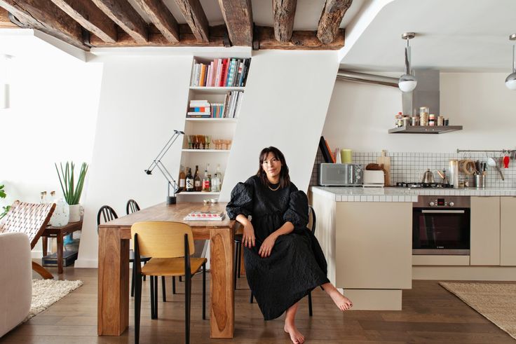 a woman sitting at a table in a kitchen