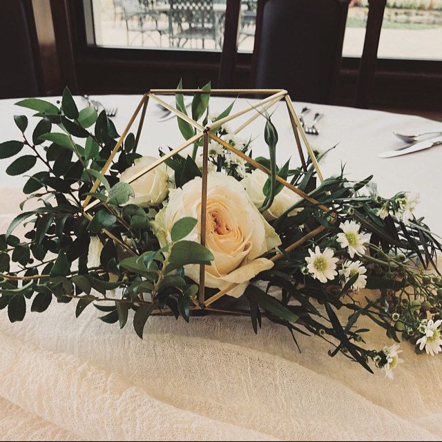 a white flower arrangement sitting on top of a table