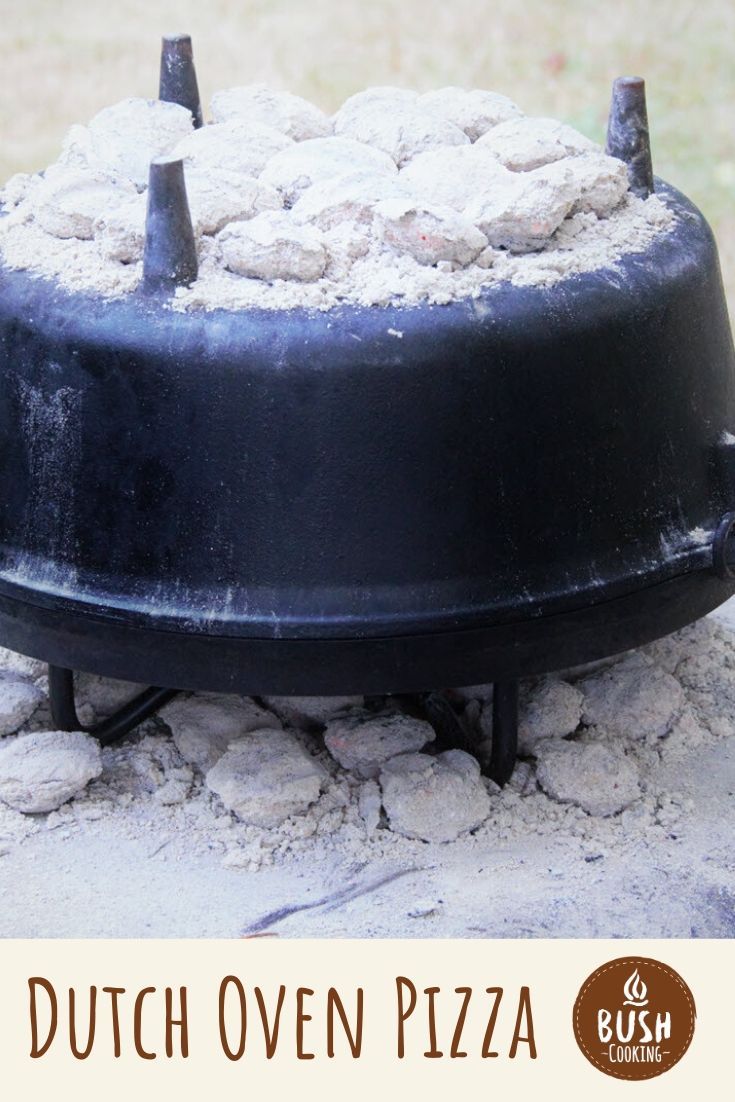 a cake sitting on top of a black plate covered in powdered sugar and toppings