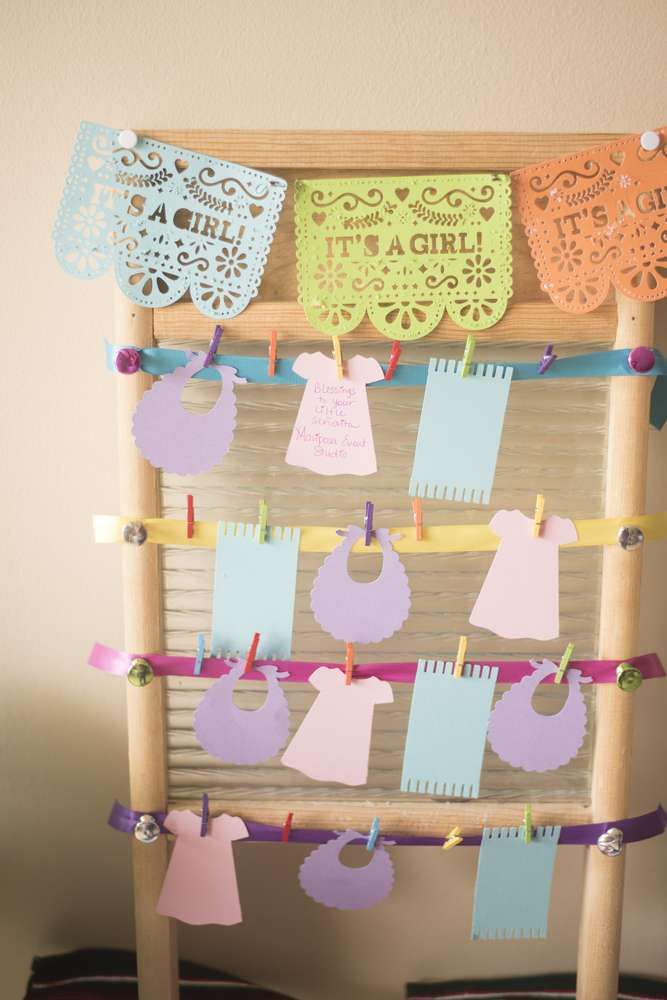 a wooden frame with clothes hanging from it's sides and paper cutouts attached to the pegs