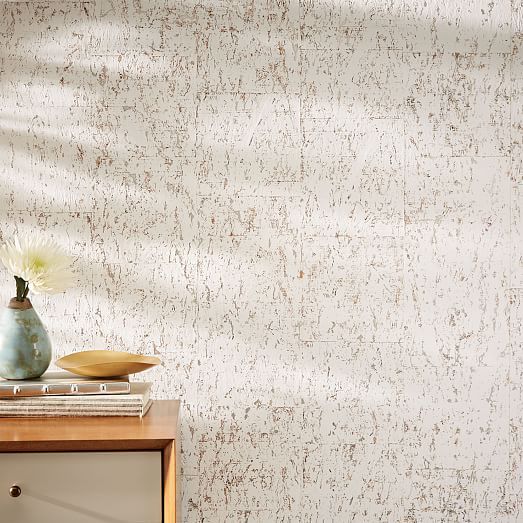 a vase with flowers sitting on top of a wooden table next to a wall paper