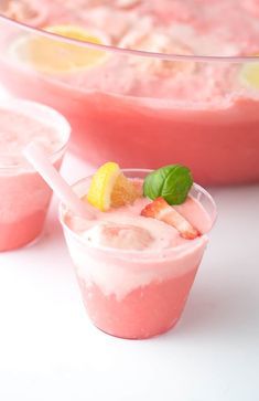 two cups filled with ice cream and fruit on the rim, next to a bowl of watermelon