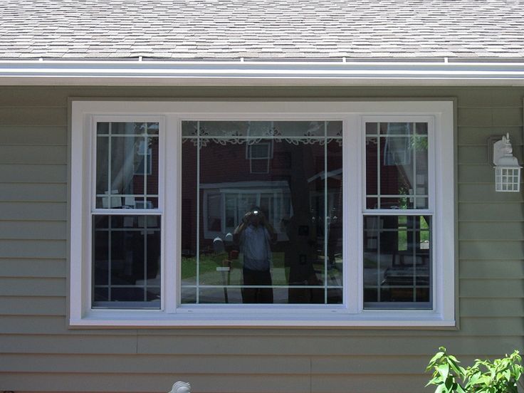 a man standing in front of a house with his back to the camera taking a photo