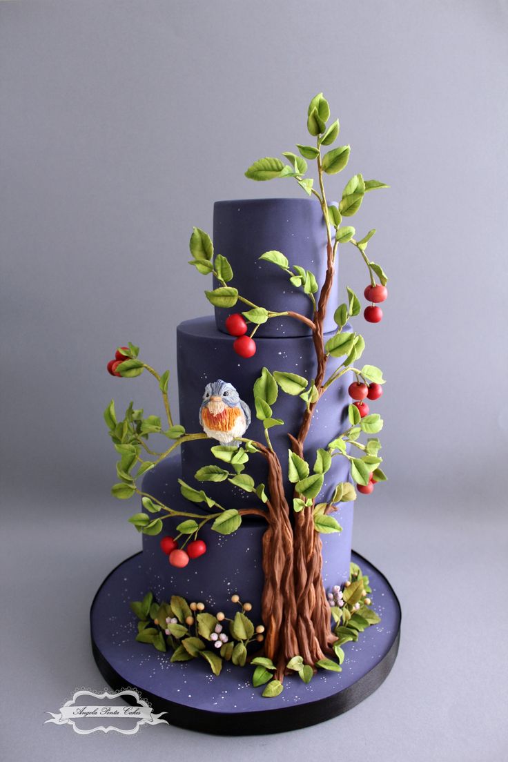 a three tiered blue cake with an owl on it's tree topper