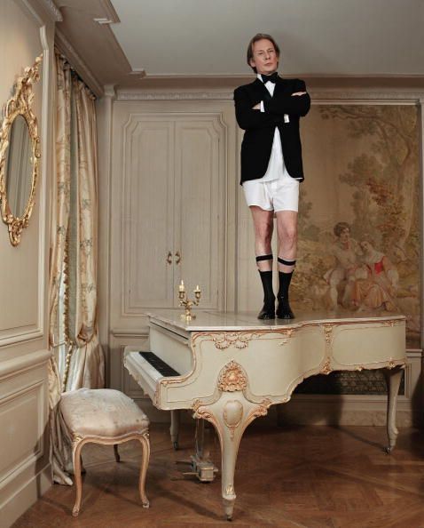 a man standing on top of a grand piano