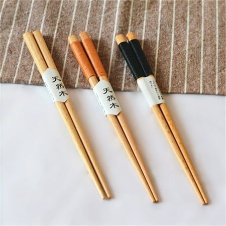 three wooden chopsticks sitting next to each other on a white tablecloth covered floor