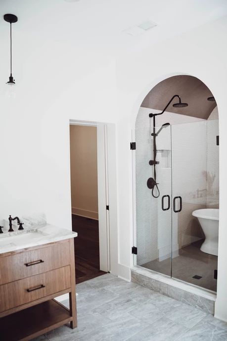 a bathroom with a sink, toilet and shower stall in the middle of the room