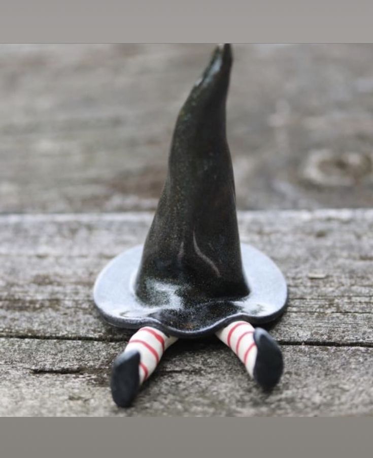 a black witches hat sitting on top of a wooden table next to candy canes