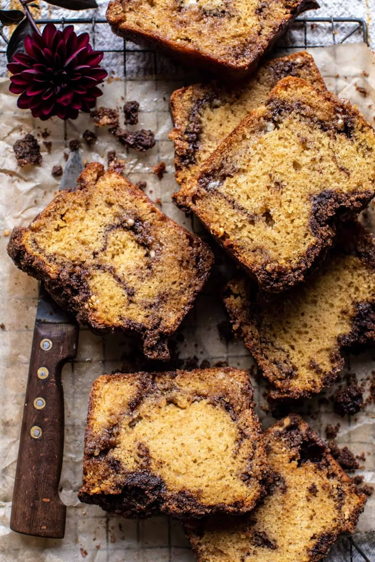 slices of chocolate chip banana bread on a cooling rack with a knife and flower in the background