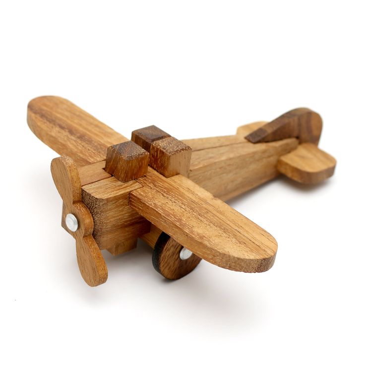 a wooden toy airplane sitting on top of a white surface