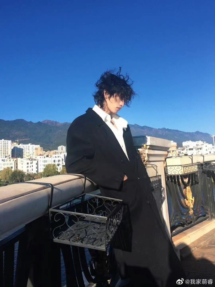 a man standing on top of a bridge next to a metal basket filled with food