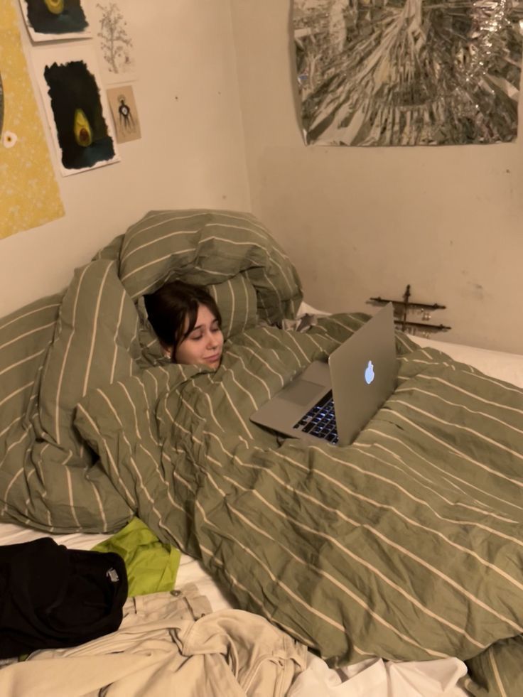 a person laying in bed with a laptop