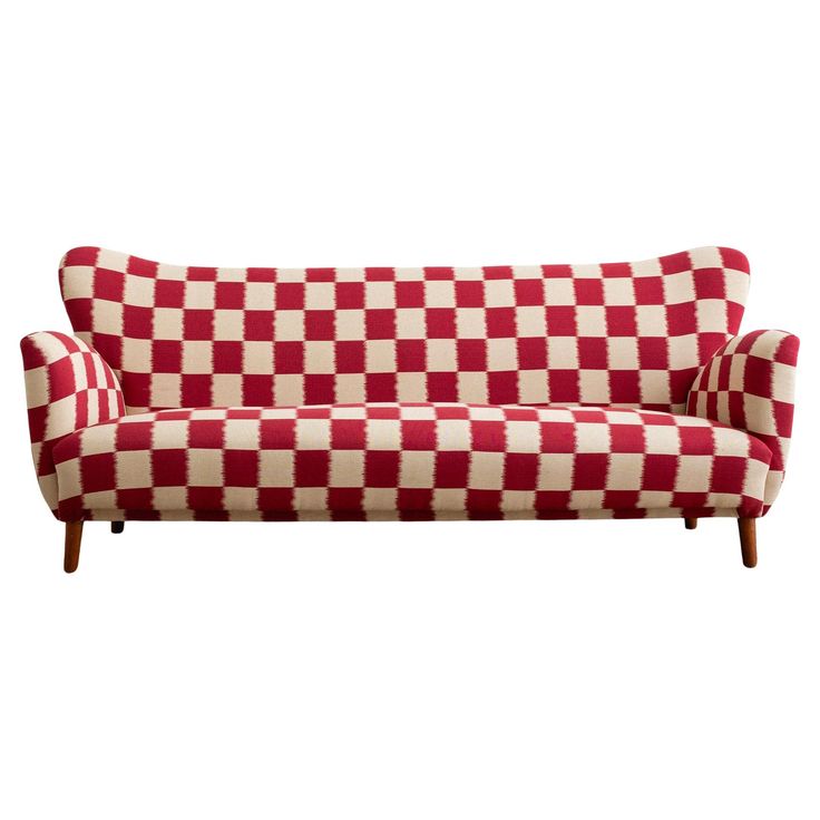 a red and white checkered couch with wooden legs