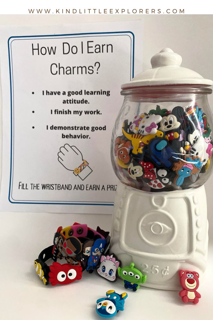 a gummy machine filled with lots of different types of toys next to a sign that says how do i earn charms?