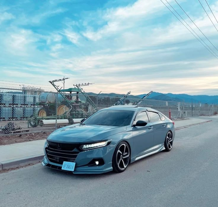 a grey car is parked on the side of the road in front of some power lines