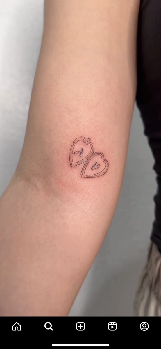 a woman's arm with a tattoo on it that has two hearts in the middle