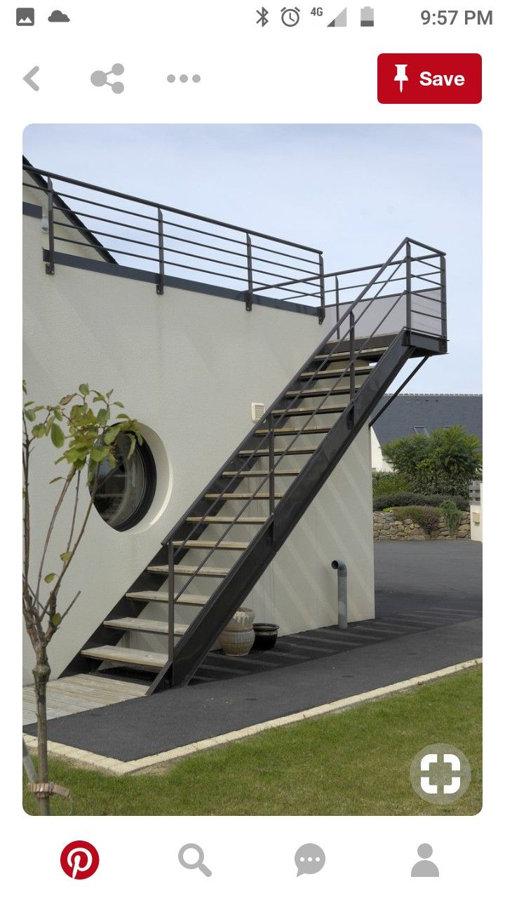 there is a white building with a metal stair case