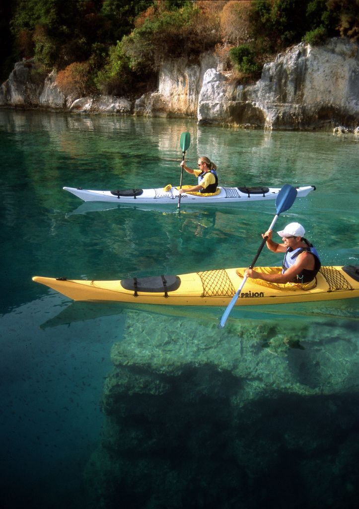 two people in kayaks paddling on the water