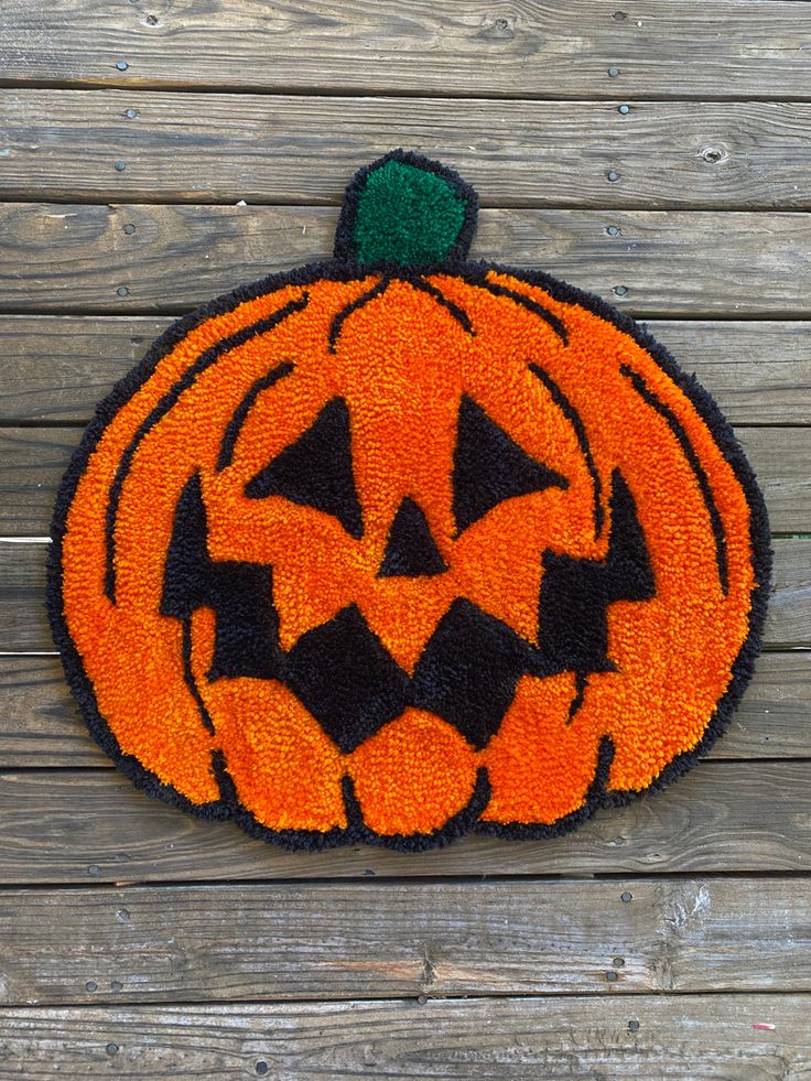 an orange and black pumpkin shaped door mat