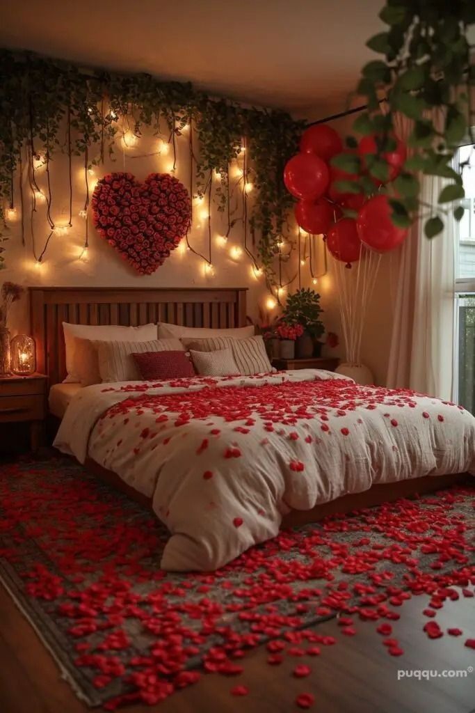 a bed with red rose petals on it and lights strung up behind the headboard