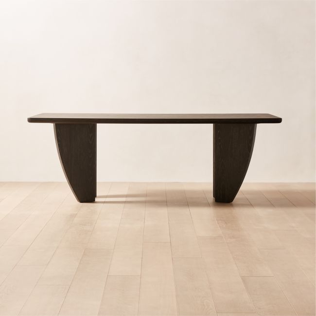 a large wooden table sitting on top of a hard wood floored floor next to a white wall