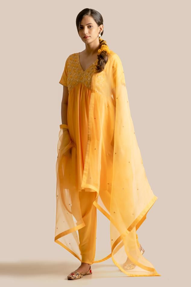 Yellow cotton silk short anarkali with floral checkered pattern, tonal resham, pitta, zari, sequin, pearl and cut dana intricate embroidered yoke. Paired with pleated cowl draped tulip pant.
Components: 2
Pattern: Embroidered
Type Of Work: Pitta, Zari, Sequin, Pearl, Cut Dana and Resham Work
Neckline: V Neck
Sleeve Type: Half Sleeves
Fabric: Cotton Silk
Color: Yellow
Other Details: 
Attached lining
Gathered flare
Deep V back
Length:
Kurta: 35 inches
Pant: 40 inches
Weight: 800 gms
Kurta Closure: Elegant Summer Salwar Kameez In Chanderi, Elegant Summer Chanderi Salwar Kameez, Summer Silk Salwar Kameez With Dabka Detail, Summer Silk Salwar Kameez With Dabka, Silk Salwar Kameez With Dabka For Summer, Summer Georgette Salwar Kameez With Dupatta, Summer Traditional Drape Georgette Salwar Kameez, Summer Georgette Dupatta With Dabka Details, Summer Designer Cotton Silk Salwar Kameez