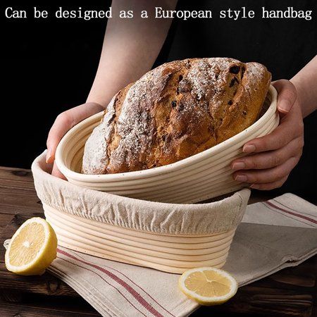 a person holding a loaf of bread on top of a wooden table next to lemon slices