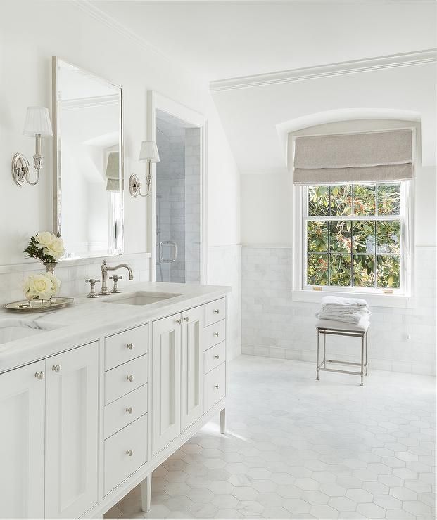 a white bathroom with two sinks and mirrors