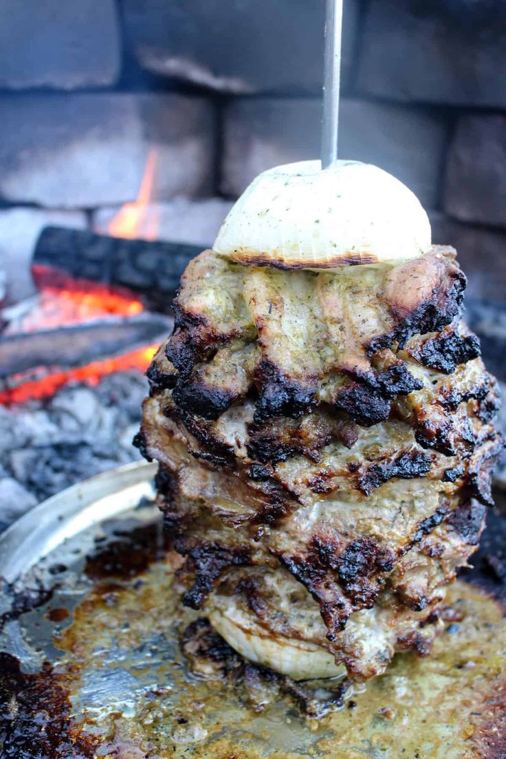 a stack of food sitting on top of a pan over an open fire pit,