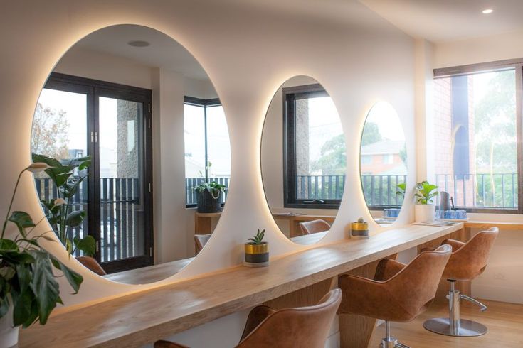 a long table with chairs and mirrors on it