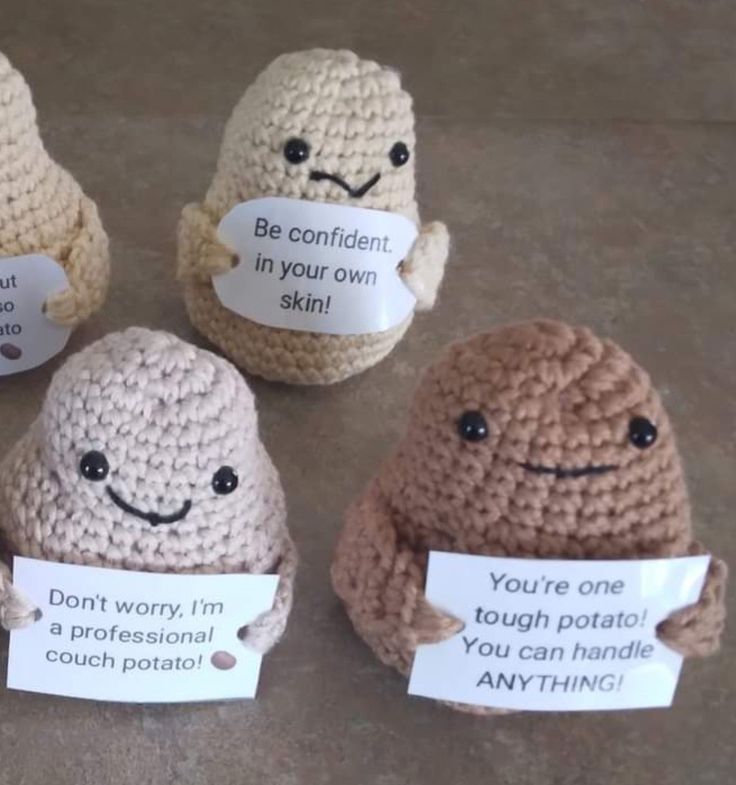 four crocheted amigurt dolls holding signs that say you're not confident in your own skin