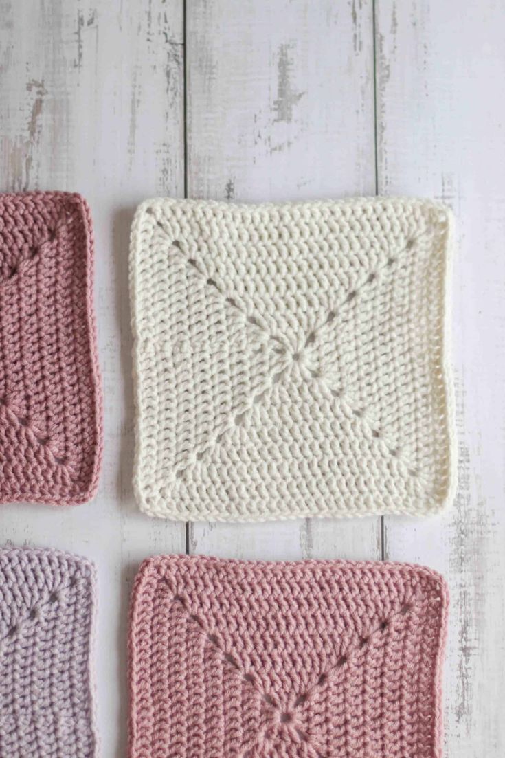 three crocheted squares on a white wooden surface