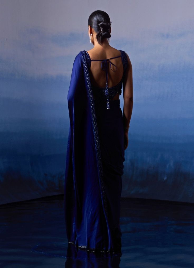 Introducing the stunning Midnight Blue Embellished Satin Saree, a perfect blend of tradition and contemporary elegance. Crafted from high-quality satin fabric, the blue saree features intricate tonal sequins, crystals and bugle beads detailing that gracefully adorns the border, adding a touch of sparkle to your ensemble. Paired with a matching blouse boasts a modern design with a chic neckline and delicate embroidery, ensuring you stand out at any event. Ideal for Mehendi, Sangeet night or as a Wedding guest. Composition : Saree and Blouse - Satin Care: Dry Clean Only and Vacuum Storage This product can be customized for sleeves, length and colour Delivery : 6-8 weeks as the product is hand crafted. Check Size Guide or choose MySize for free customisation (All Sizes above XL can be made at Iris Border, Bloom Embroidery, Saree Gowns, Dhoti Saree, Cotton Sarees Handloom, Satin Embroidery, Border Saree, Indian Wedding Wear, Satin Saree