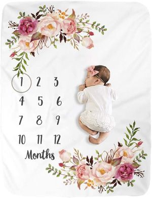 a baby is laying down in front of a floral frame with the date on it