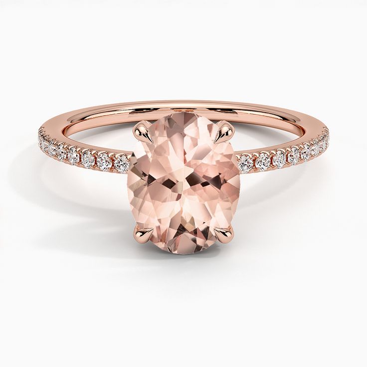 an oval cut peach morganite ring with pave set diamonds on the shoulders and sides