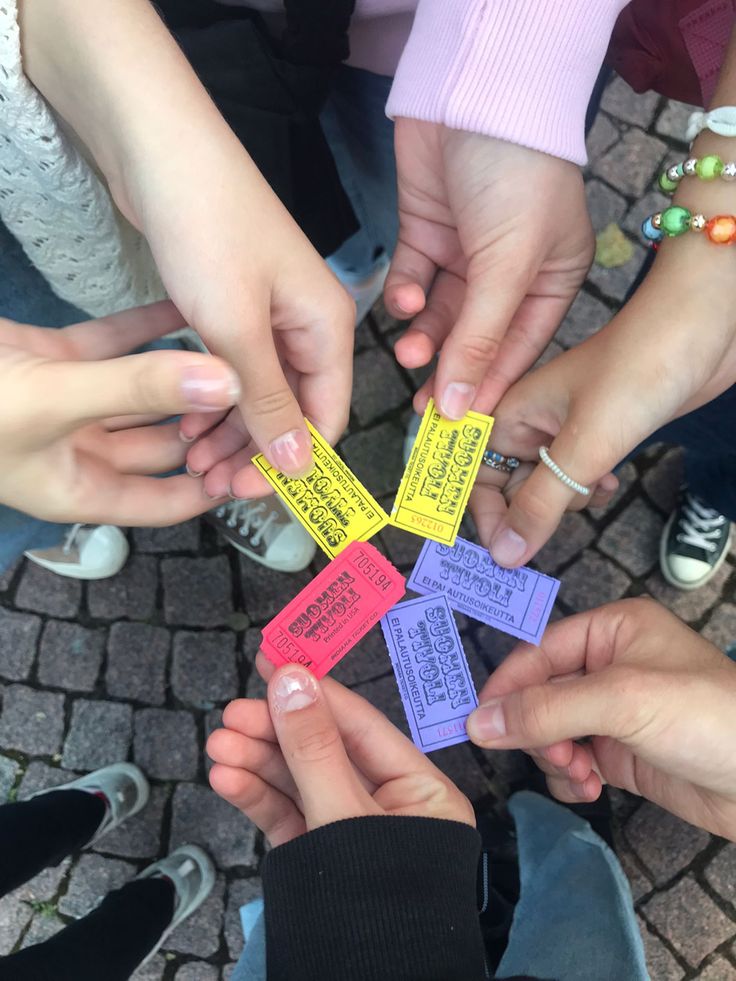 several people are holding small pieces of paper with words on them in the shape of squares