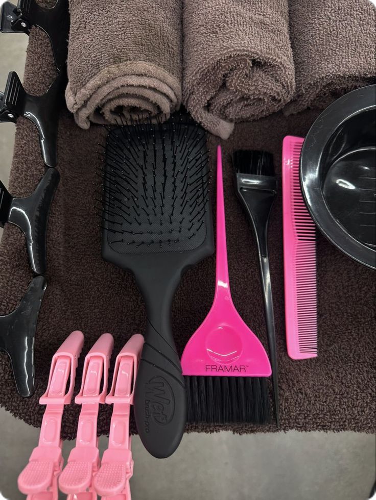 a pile of hair brushes and combs sitting on top of a towel next to other items