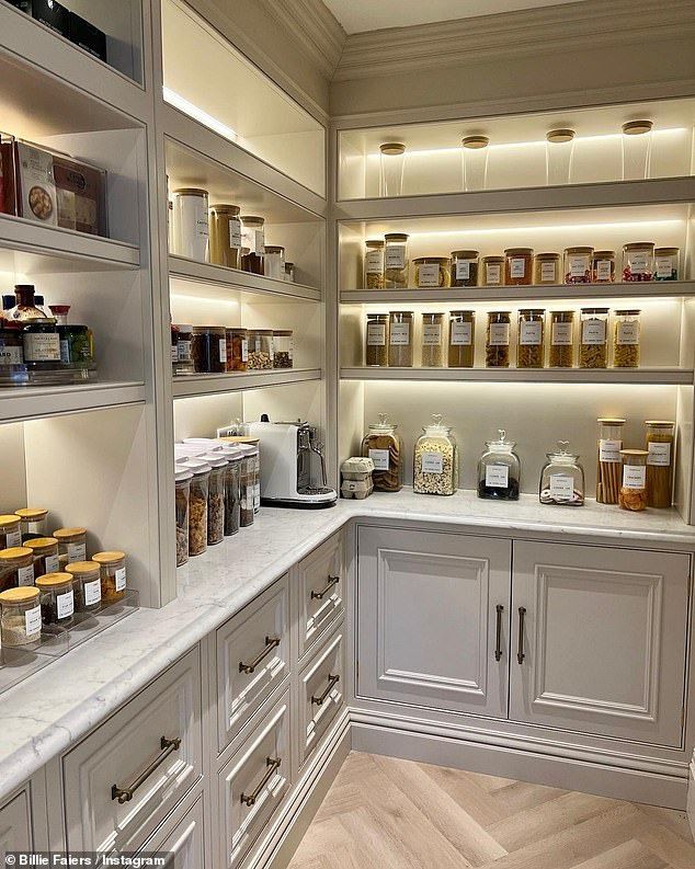 a kitchen filled with lots of white cupboards and counter top covered in food items