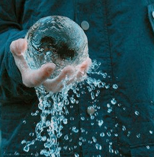 a person holding an object with water coming out of it