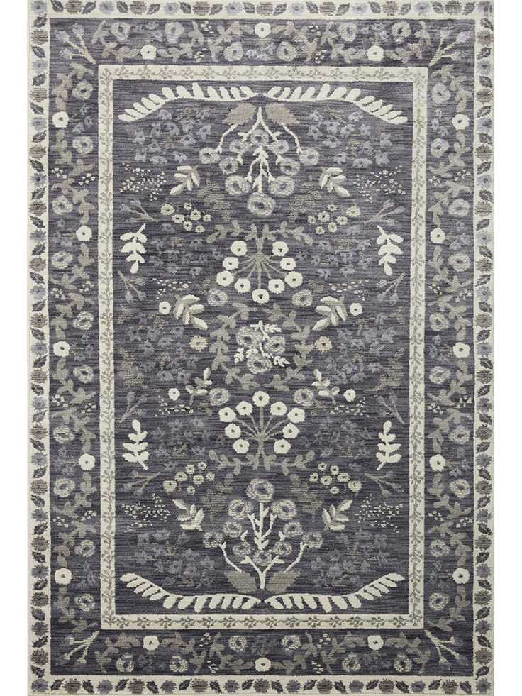 a rug with an ornate design on the front and back side, in grey tones