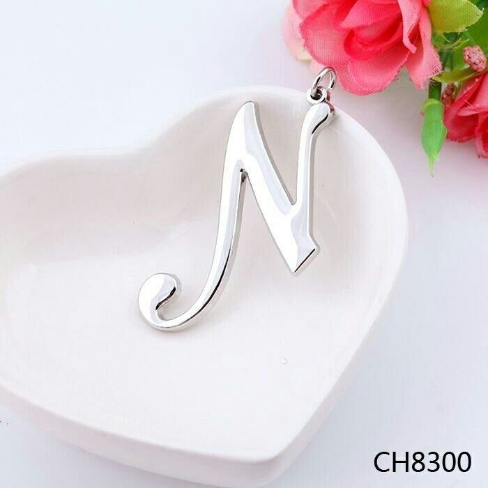 the letter n is on top of a heart shaped dish with flowers in the background