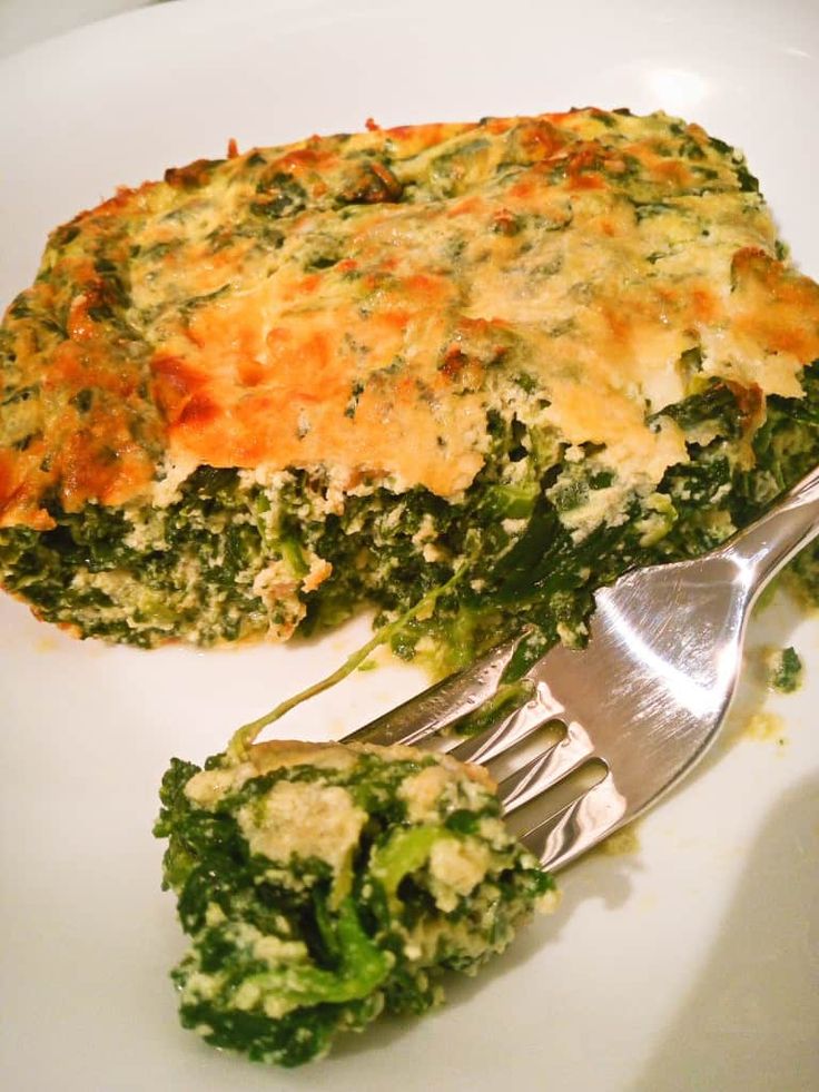 broccoli and cheese casserole on a white plate with a silver fork