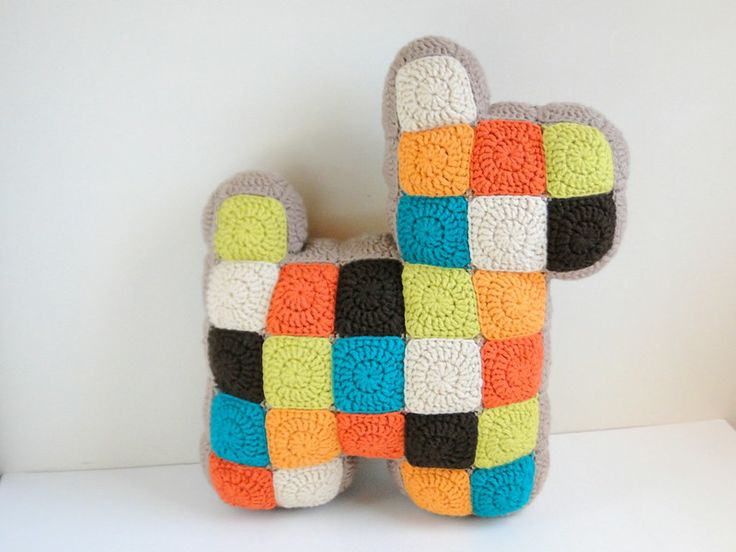 a crocheted stuffed animal made to look like a dog's head with multi - colored squares on it