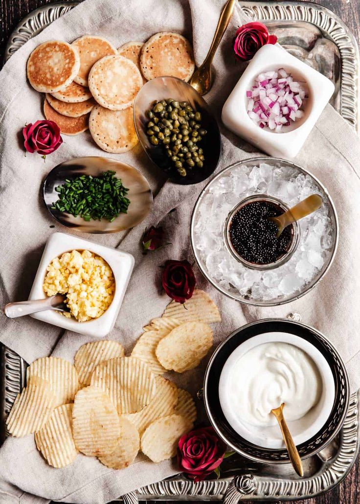 a tray filled with different types of food on top of a white cloth covered table