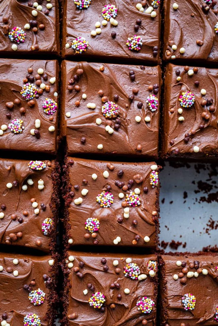 chocolate brownies with sprinkles and colored candies are arranged in rows