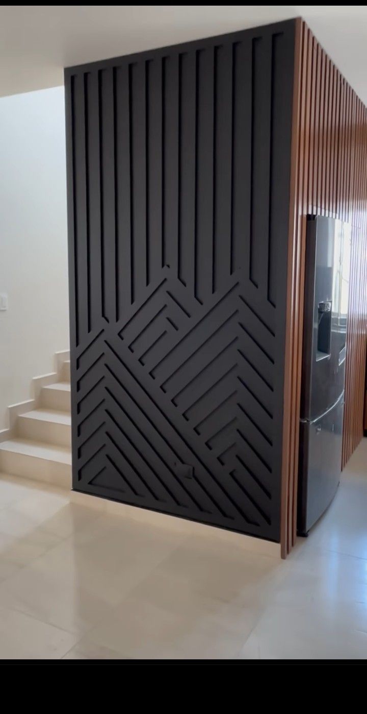 a room that has some stairs and a door in it with black panels on the wall