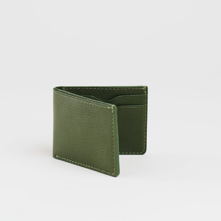 A perfectly practical bi-fold wallet constructed in our milled leather, for those who know exactly what they need. The Jackson bi-fold features four fully lined card pockets with our signature curve and hand wrought heat-creased edge, as well two interior pockets and a bill fold. Dimensions: 4.25" x 3.25" Classic Green Trifold Wallet For Everyday Use, Classic Green Leather Wallets, Classic Green Leather Trifold Wallet, Modern Green Bifold Wallets, Modern Green Bifold Wallet, Green Bifold Wallet For Formal Occasions, Green Leather Bifold Wallet, Classic Green Trifold Wallet With Card Slots, Classic Green Wallet With Rfid Blocking