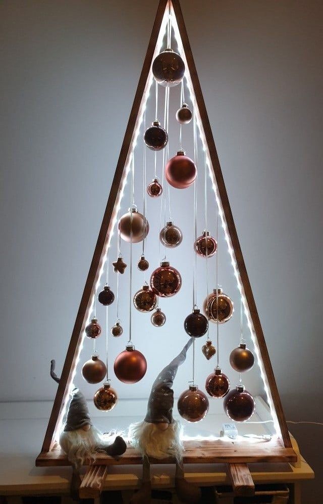 a christmas tree with ornaments hanging from it's sides and lights on the top