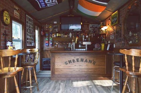 the inside of a small bar with wooden stools and tables in front of it