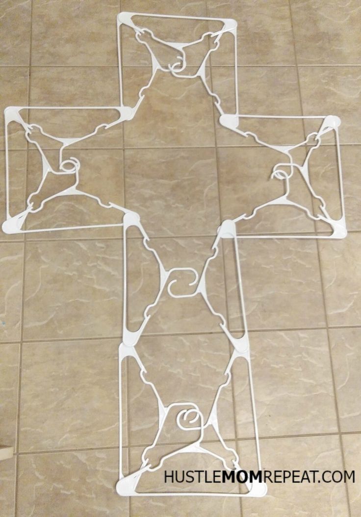 a cross made out of paper sitting on top of a tiled floor